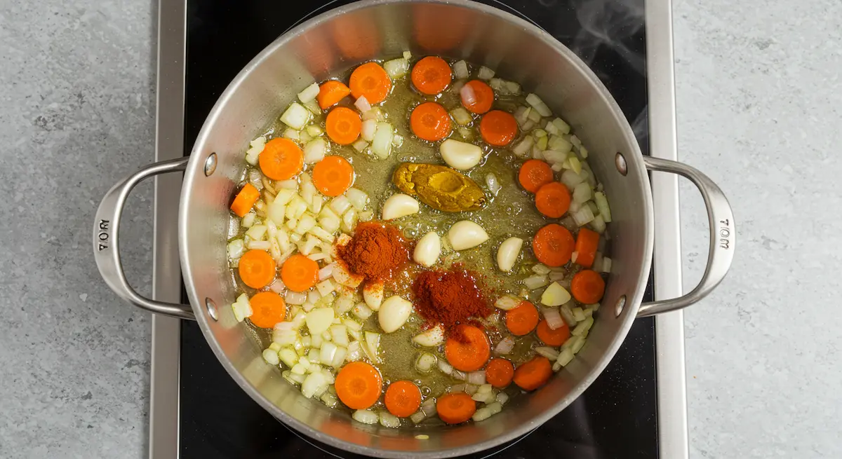 Sautéing onions, garlic, carrots, turmeric, and paprika for garlic lentil rice
