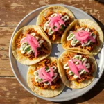 Easy 30-minute carnitas tacos with crispy pork, pickled onions, and crema – better than street food