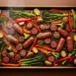Sausage and Veggie Sheet Pan Miracle: A Superb 40-Min Dinner Final roasted sausage and vegetable sheet pan dinner with charred potatoes, broccoli, and peppers, garnished with parsley, on a dark wood table.