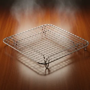 Metal wire cooling rack for draining crispy fried fish on polished wood table